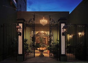 A gated entrance with a chandelier, potted plants, and a fountain. - The Pontchartrain Hotel (New Orleans)