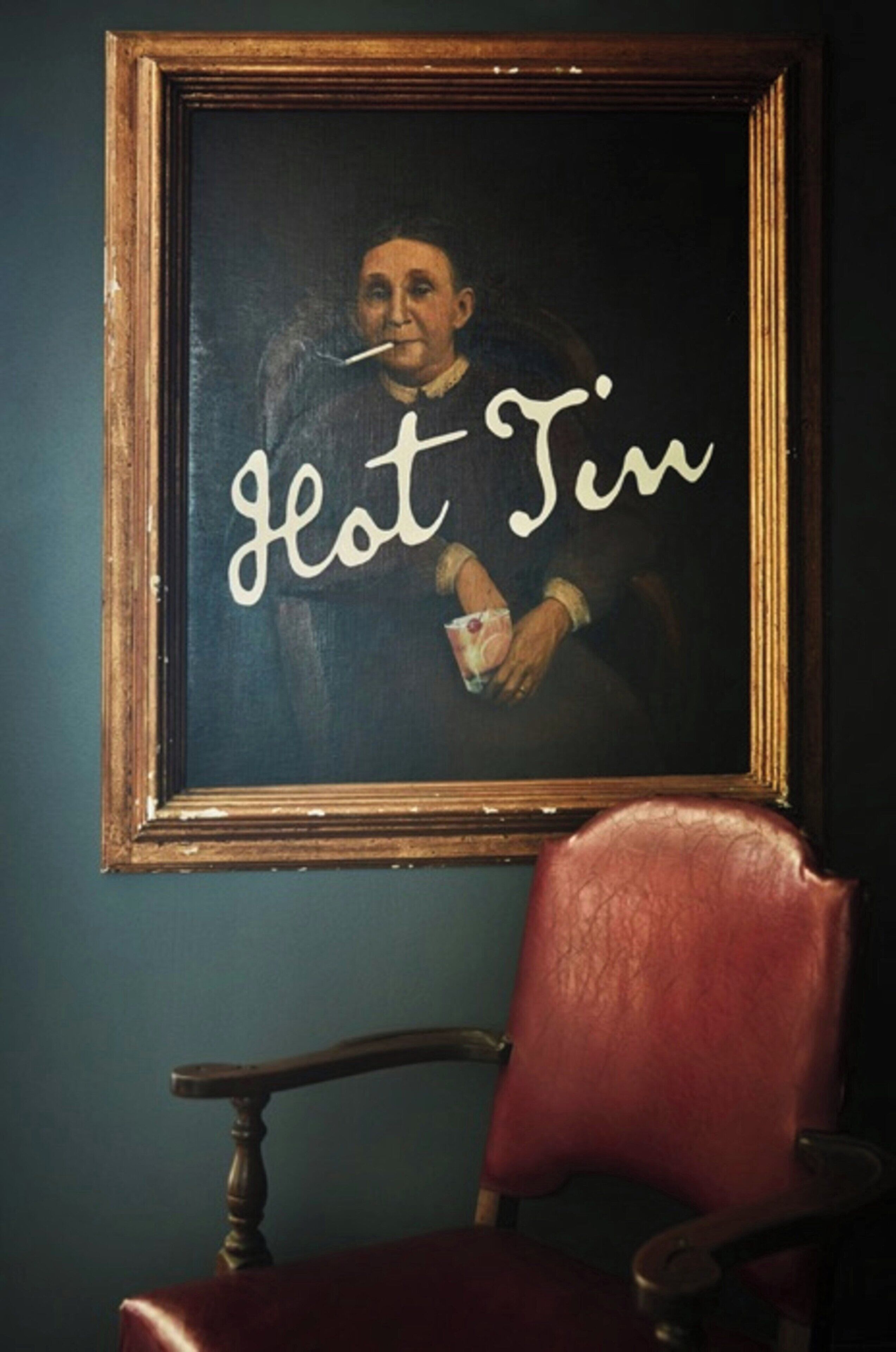 Una obra de arte enmarco con el texto 'Hot Tin' sobre un fondo oscuro.