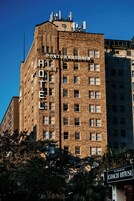 A hotel building with a sign reading 'PONTCHARTRAIN HOTEL' and another sign for 'ST. CHARLES COACH HOUSE' in the foreground.