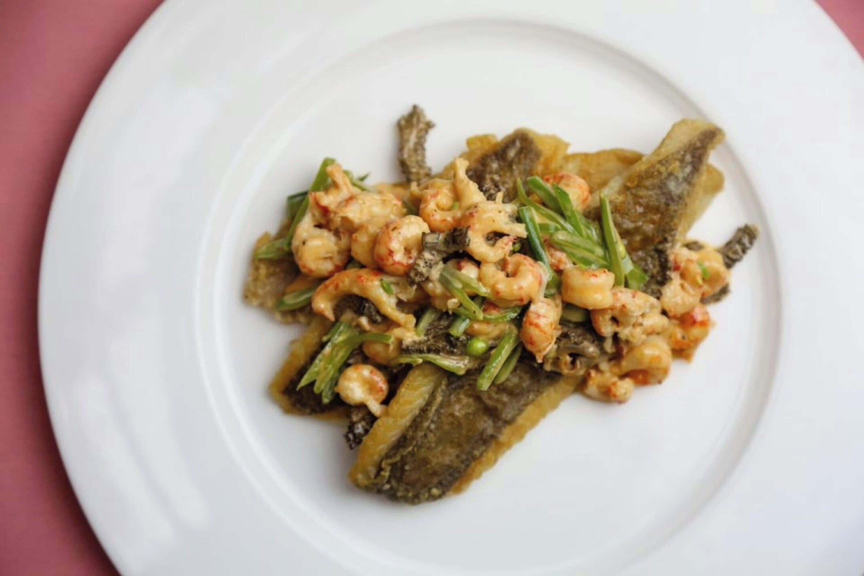 A plate of food with shrimp and vegetables on a white plate.