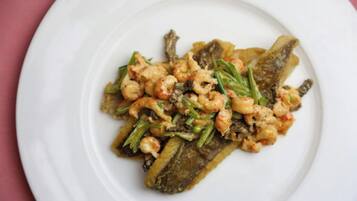 A plate of food with shrimp and vegetables on a white plate.
