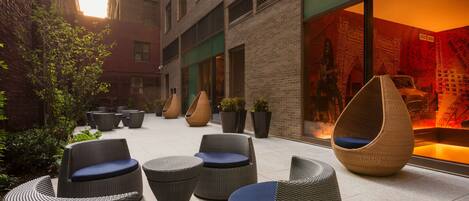 A courtyard with wicker furniture and potted plants.