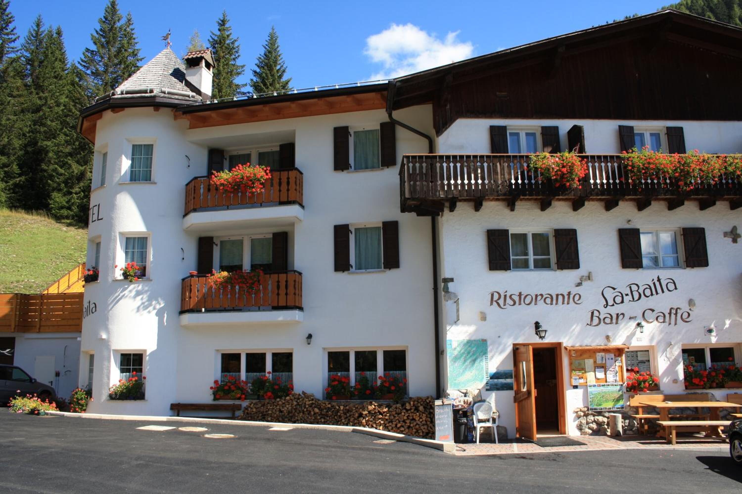 A two-story building with balconies, a bar area, and a sign for a restaurant.