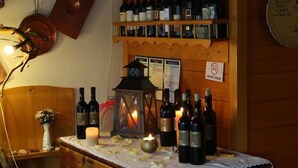 Un'area con bancone in legno, bottiglie di vino, una candela e un lanterna.