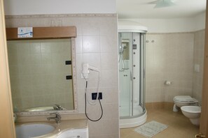 A bathroom with a sink, mirror, and a glass-enclosed shower. - Albergo Ristorante La Baita (Livinallongo del Col di Lana)