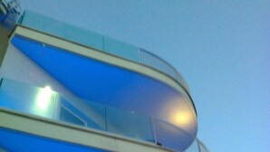 A modern building with a curved, multi-level design. - L'Approdo (Anzio)