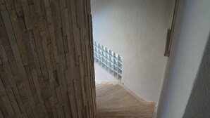 A wooden staircase with a view of a tiled wall at the top. - L'Approdo (Anzio)