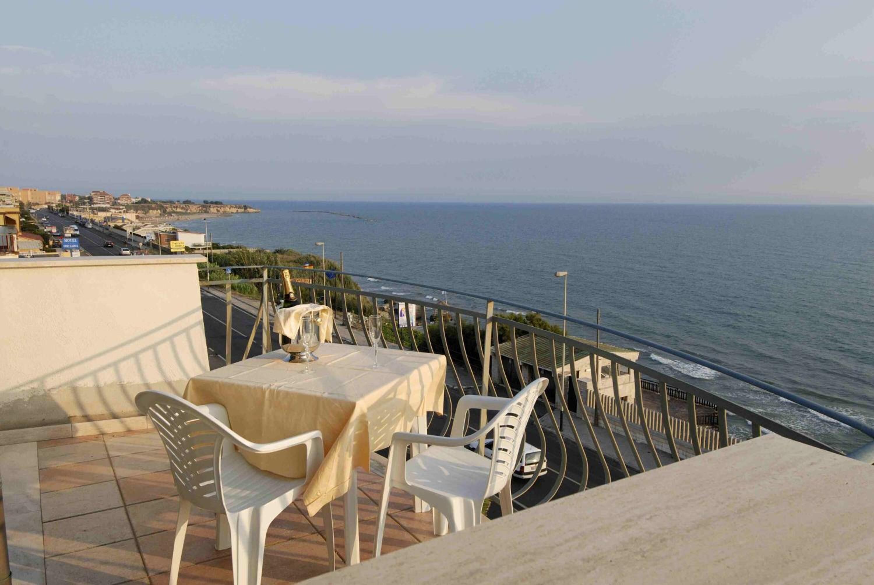 Una terrazza con tavolo e sedie vista mare.