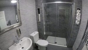 A bathroom with a sink, toilet, and glass-enclosed shower. - May's House (Liverpool)