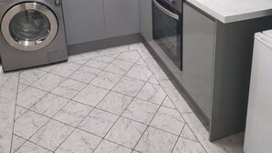 A compact kitchen with a washing machine, a sink, and a stove. - May's House (Liverpool)