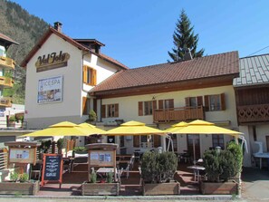 Un restaurant avec une terrasse, des parasols jaunes et une enseigne indiquant la présence d’un spa proposant des soins à base de glace.