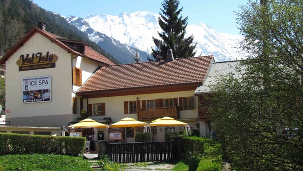 A hotel with a sign for an ice spa and outdoor seating with umbrellas. - Hôtel Val Joly (Saint-Gervais-les-Bains)