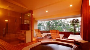 A spa area with a hot tub, wooden deck, and seating area with chairs. - Monjusou (Miyazu)
