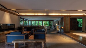 A spacious living area with a fireplace, seating, and a view of the outdoors. - Monjusou (Miyazu)