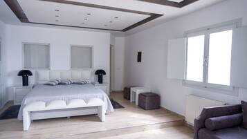 Un dormitorio moderno con una cama grande, mesitas de noche, una ventana y un radiador.