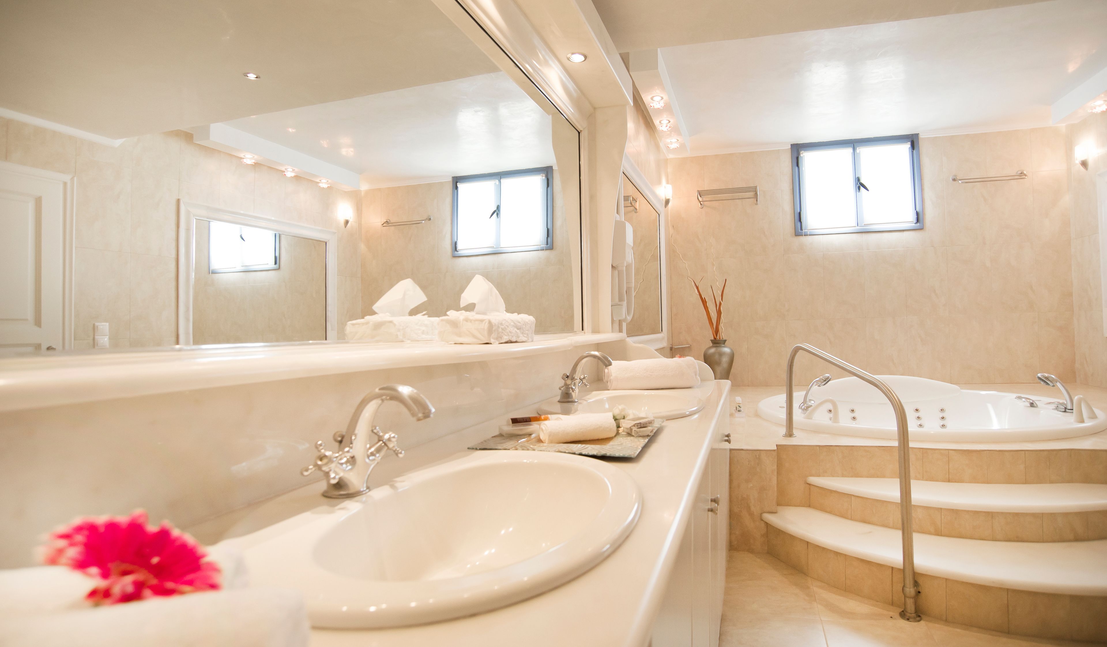 A modern bathroom with a large mirror, a sink, a bathtub, and a shower.