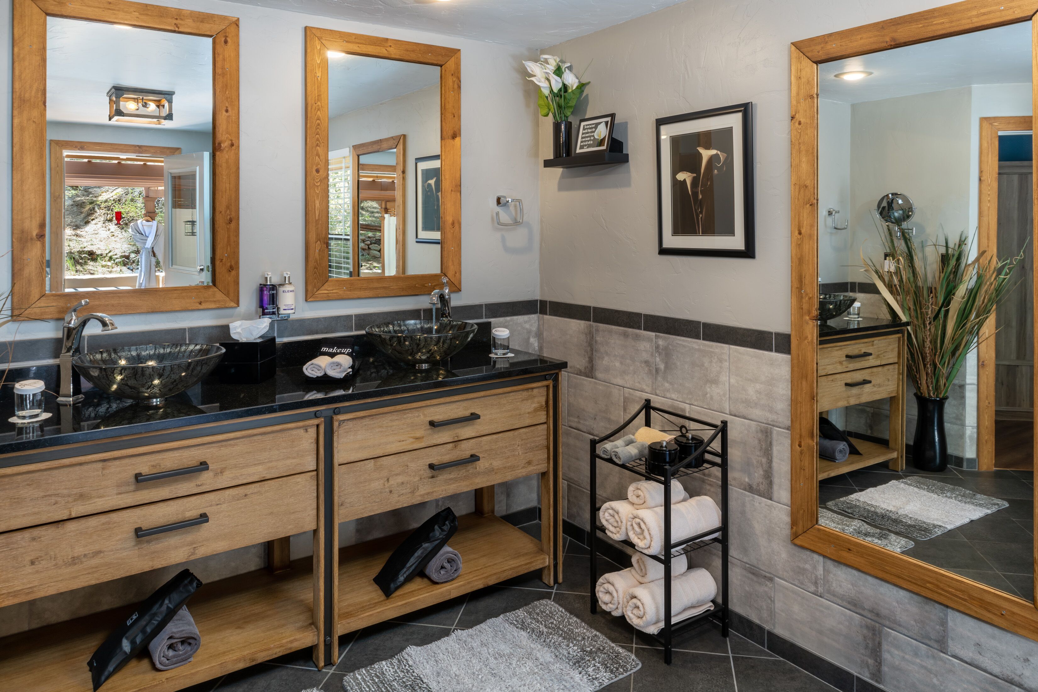 A modern bathroom with a double sink, wooden vanity, and a towel rack.