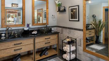 A modern bathroom with a double sink, wooden vanity, and a towel rack.