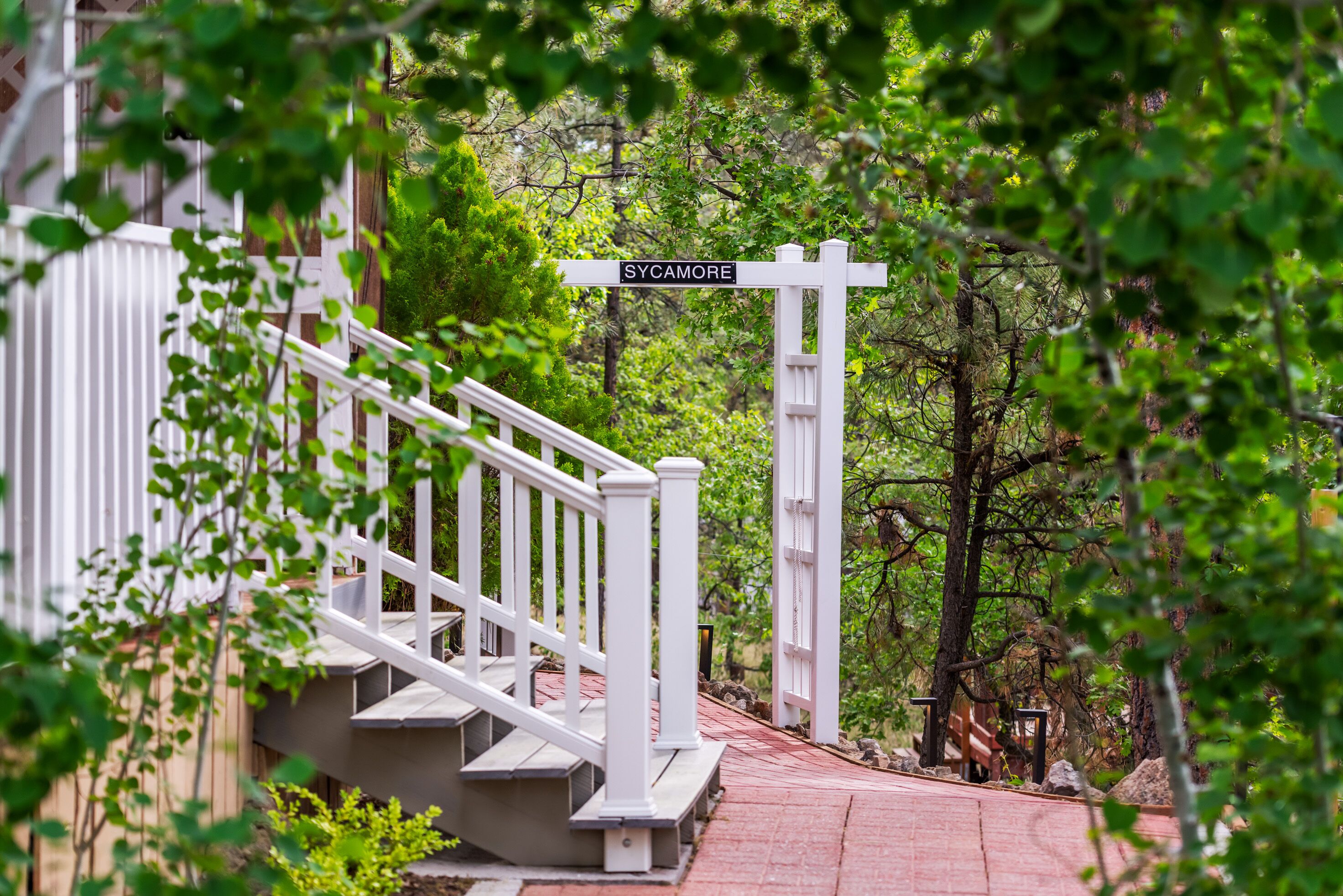 A staircase leading to a gate with a sign reading "SYCAMORE."
