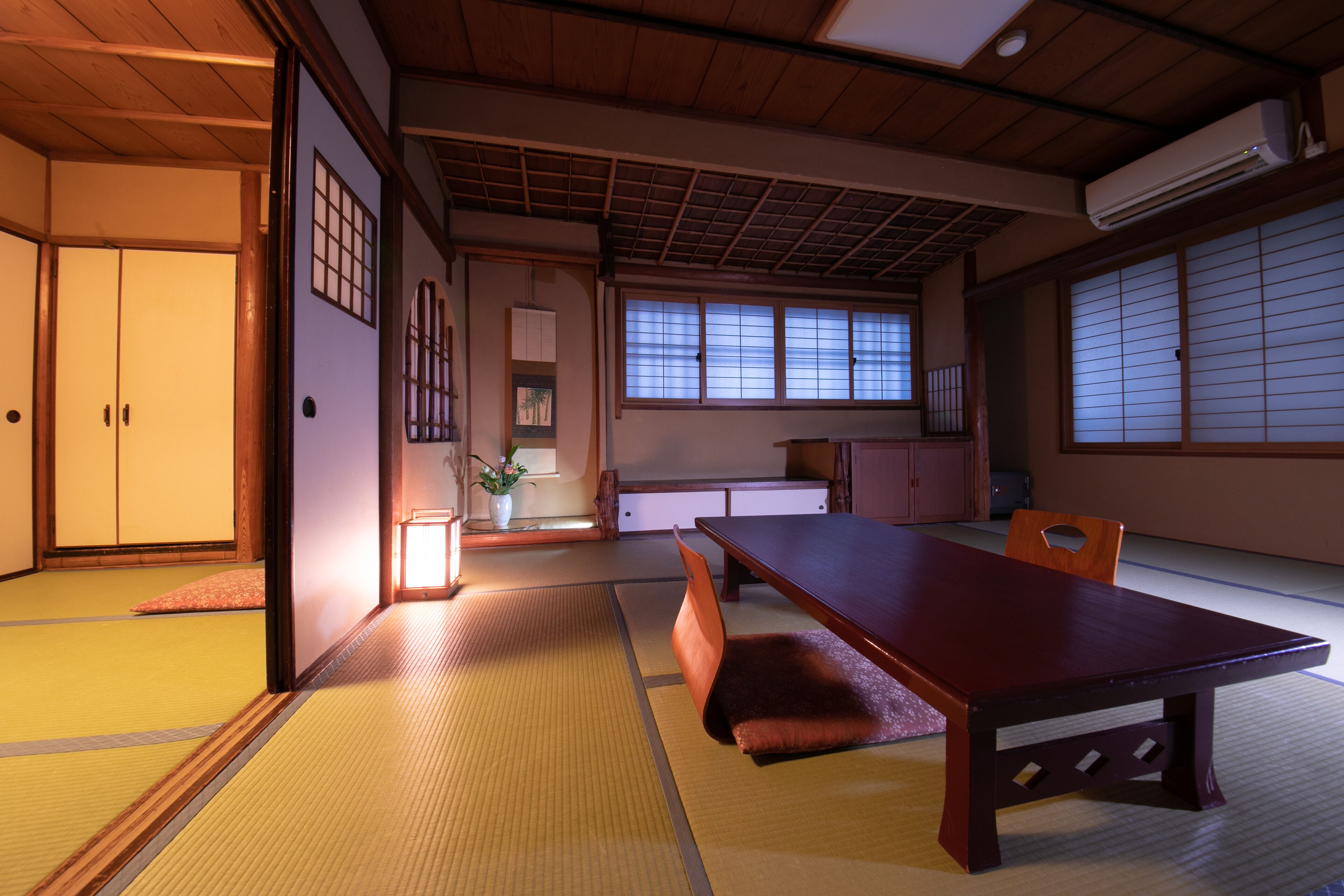 Une pièce de style japonais traditionnel, avec un sol recouvert de tatamis, une basse table en bois et des portes coulissantes.