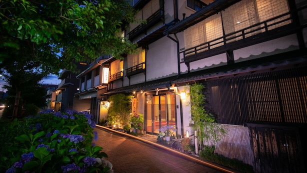A traditional Japanese-style building with a covered entrance and a garden with purple hydrangeas. - Hokkaikan Ohanabo (Kyoto)