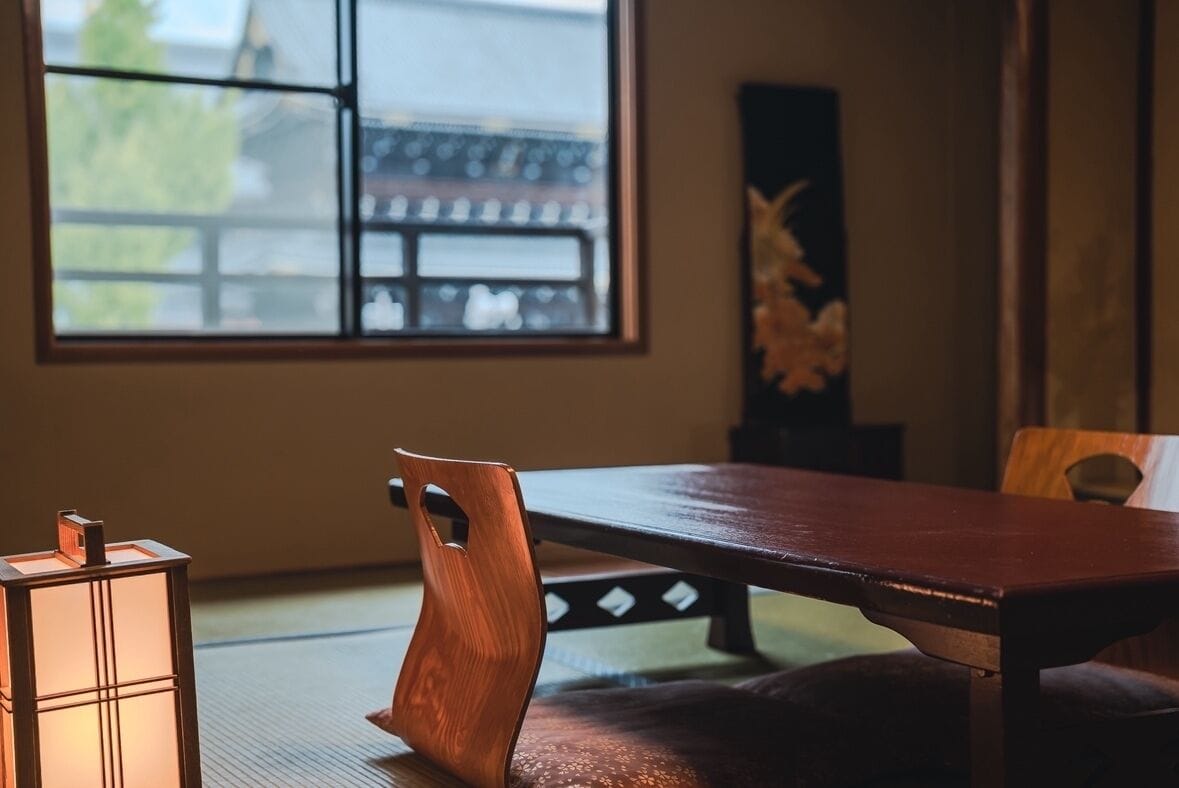Une pièce de style japonais traditionnel, avec un sol recouvert de tatamis, une table basse et un banc rembourré.