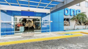 A modern building with a glass entrance and a blue facade. - One Salina Cruz (Salina Cruz)