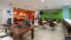 A cafeteria with tables and chairs, a computer on a table, and a sign for free Wi-Fi. - One Salina Cruz (Salina Cruz)