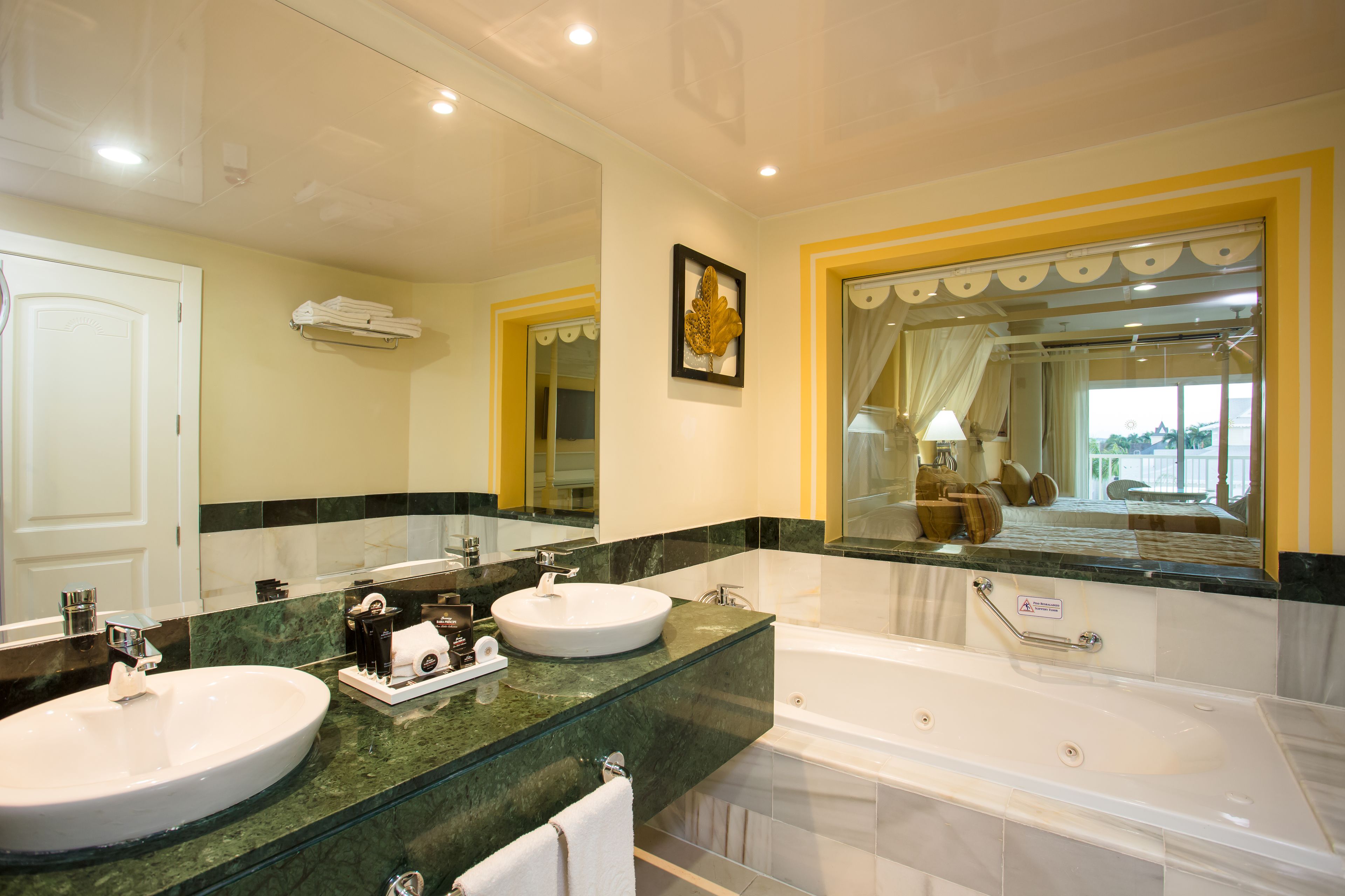 A bathroom with two sinks, a bathtub, and a large mirror.