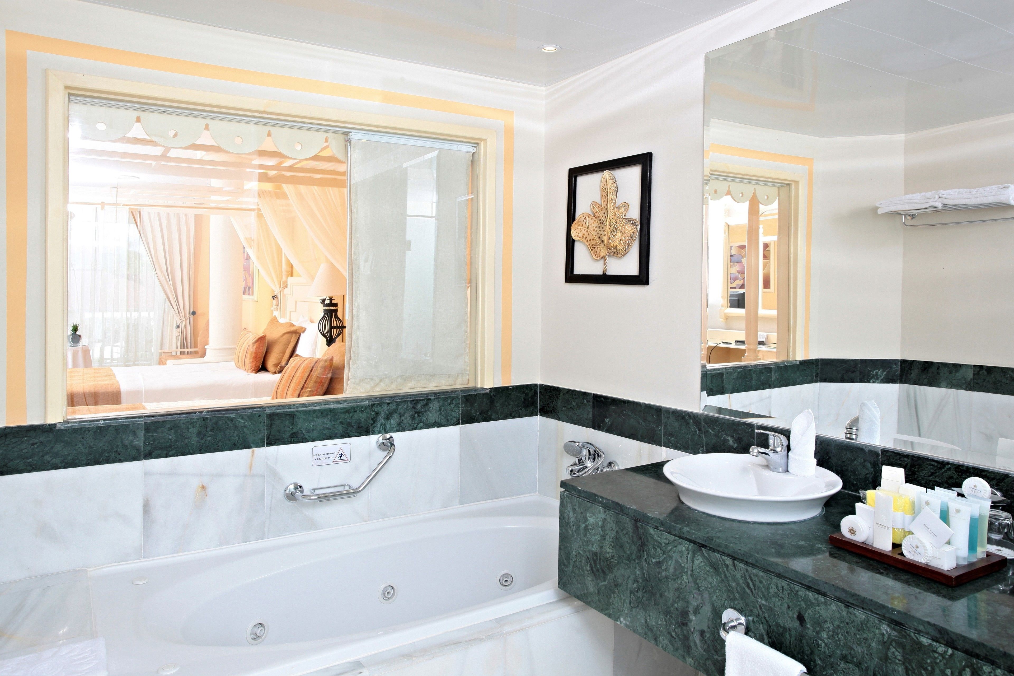 A modern bathroom with a large bathtub, a sink, and a vanity mirror.