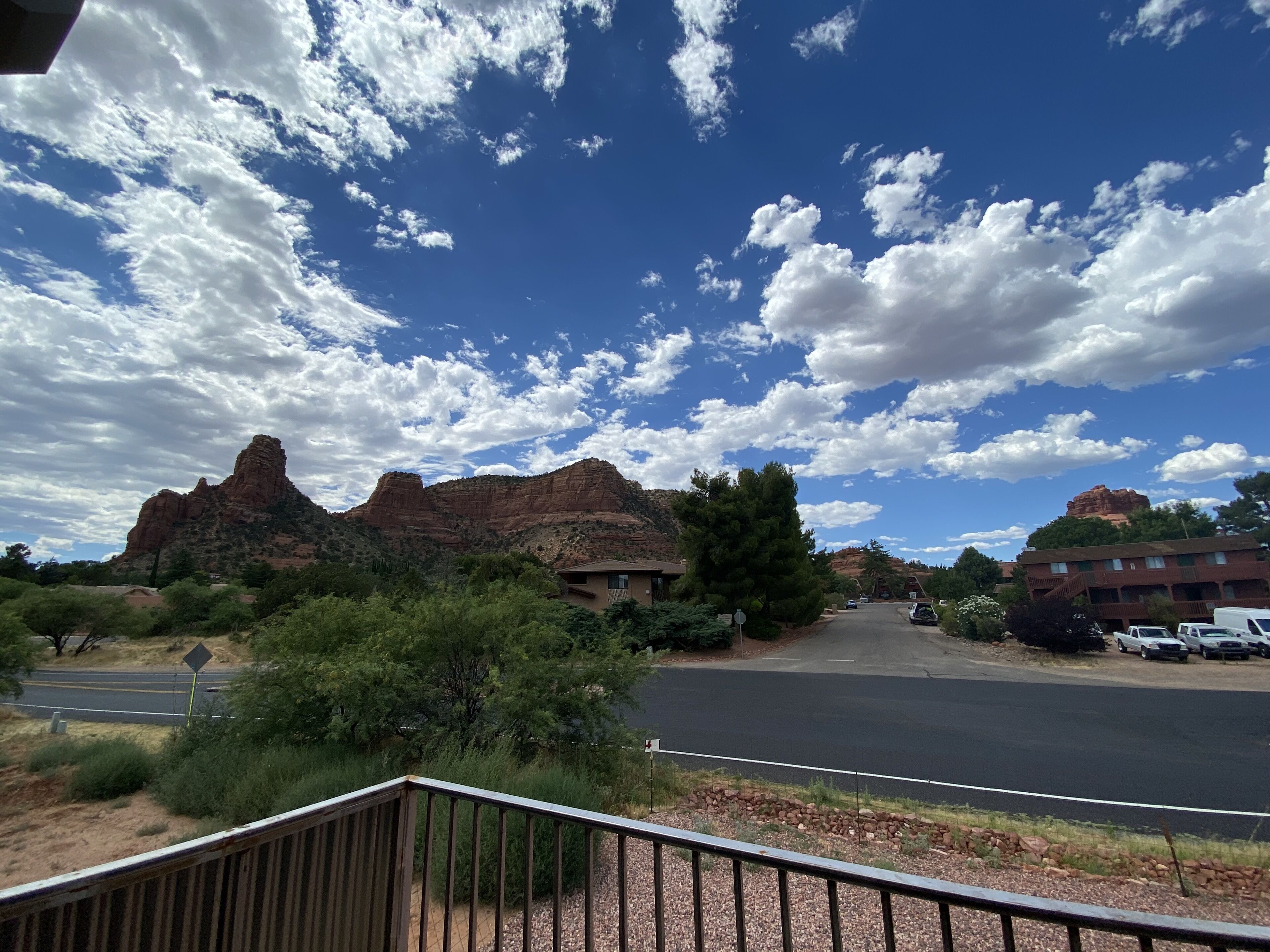 A road leading to a building with a mountain backdrop.