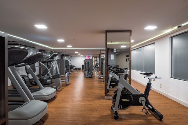 A gym with treadmills, stationary bikes, and weight machines.