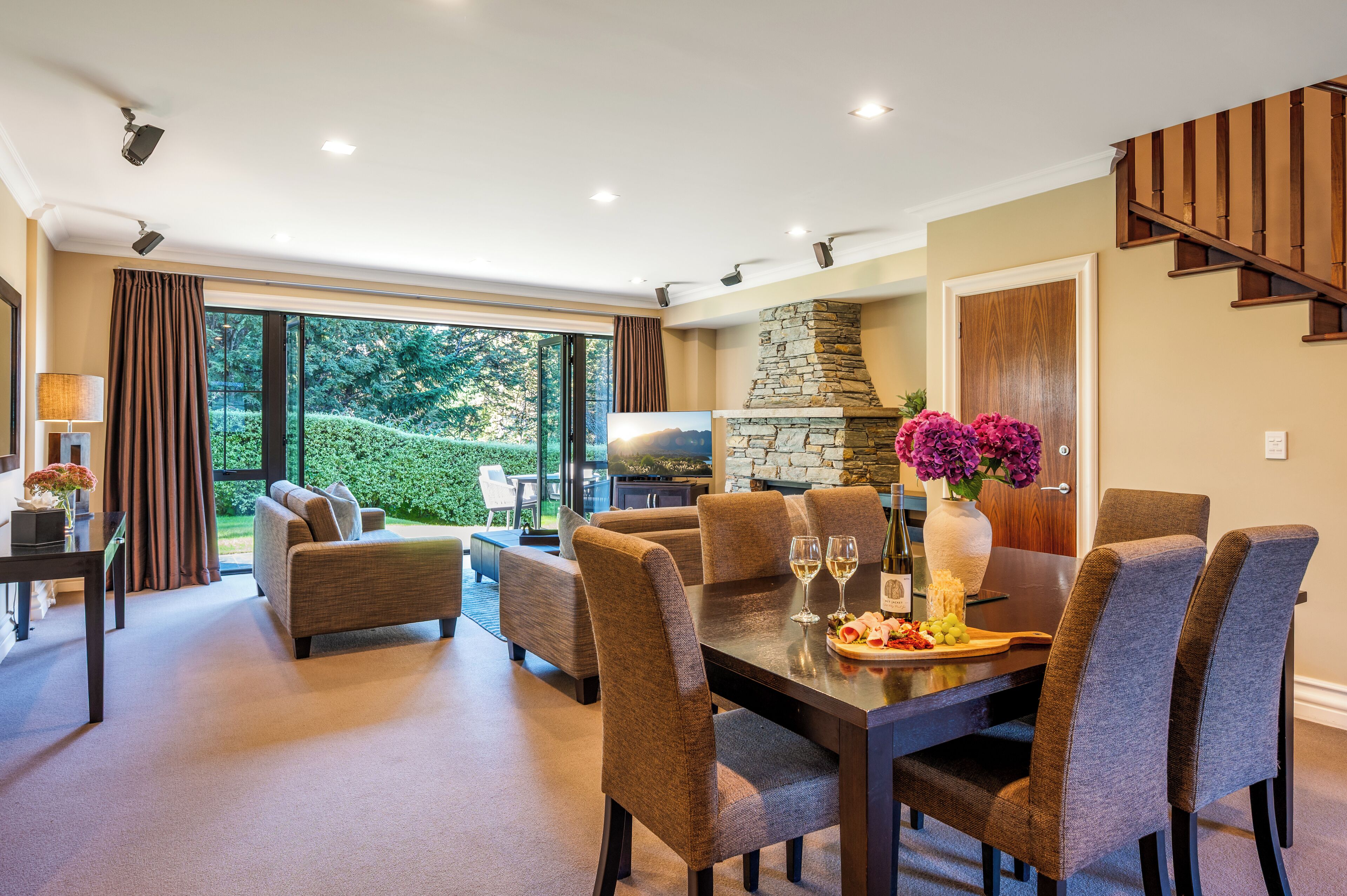 A dining area with a stone fireplace, a large window, and a view of the outdoors.
