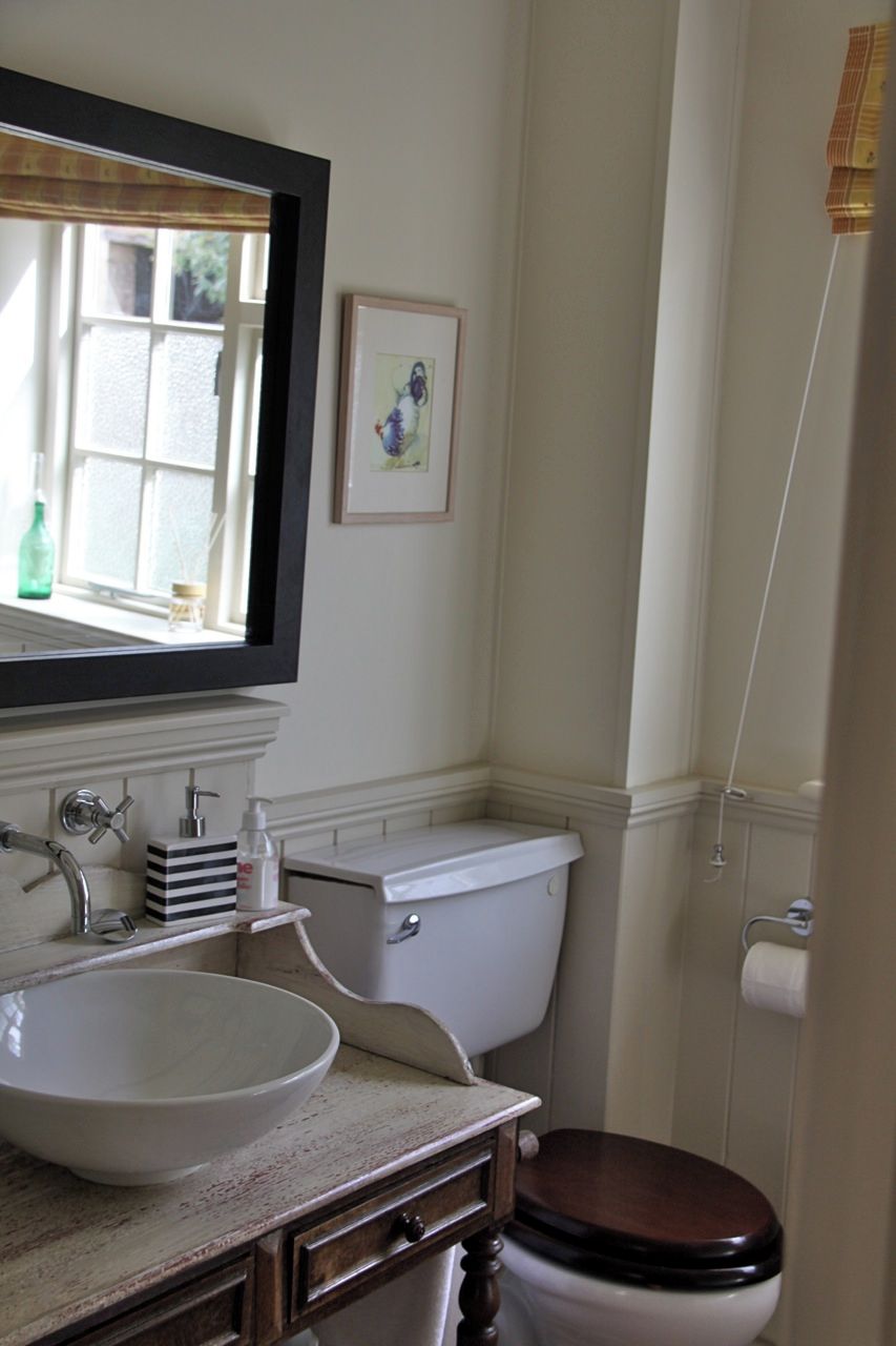 A bathroom with a white sink, a toilet, and a mirror above the sink.
