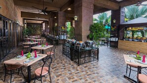 Un restaurante amplio con varias mesas, una zona de bufé y un ventilador de techo.