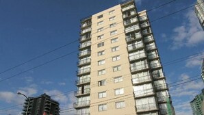A high-rise building with multiple balconies and a green awning. - Tropicana Suite Hotel (Vancouver)