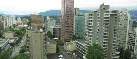 A high-rise hotel with multiple floors, a parking lot, and a view of surrounding buildings and greenery.