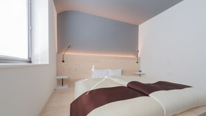 Un dormitorio moderno con cama, mesitas de noche y cabecera.