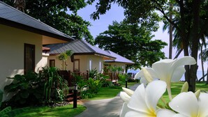 A pathway leading to a building with a tiled roof and a well-maintained lawn. - Promtsuk Buri Resort (Koh Samui)
