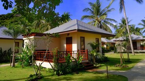 A resort with a single-story building, a porch with a red railing, and a well-maintained lawn. - Promtsuk Buri Resort (Koh Samui)