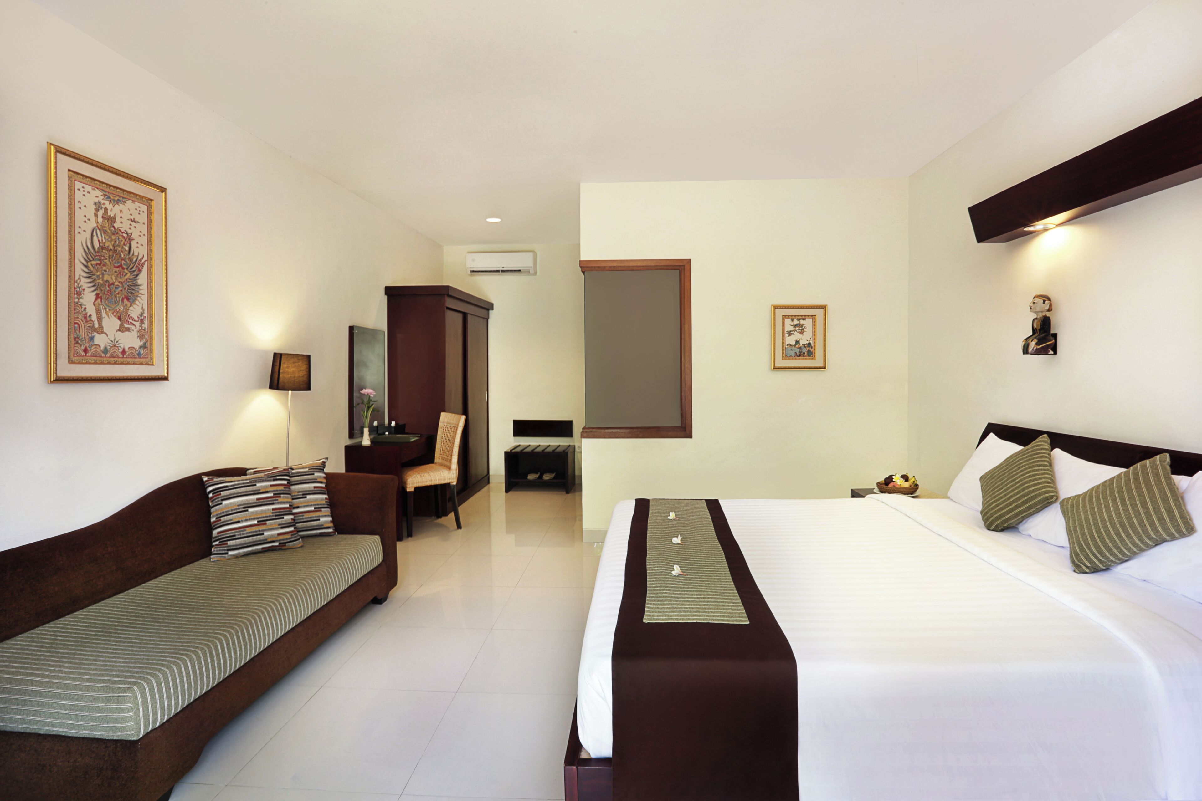 Une chambre d’hôtel avec un lit, un canapé, un bureau et une chaise.