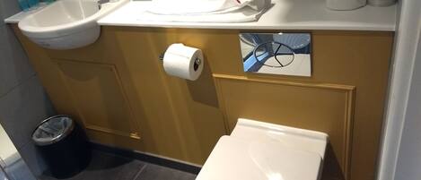 A bathroom with a sink, toilet, and a towel rack.