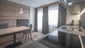 Una cocina moderna con una mesa de comedor de madera, un taburete de bar y un lavamanos empotrado.