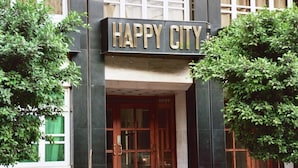 Entrada de un edificio con un letrero que dice "HAPPY CITY".