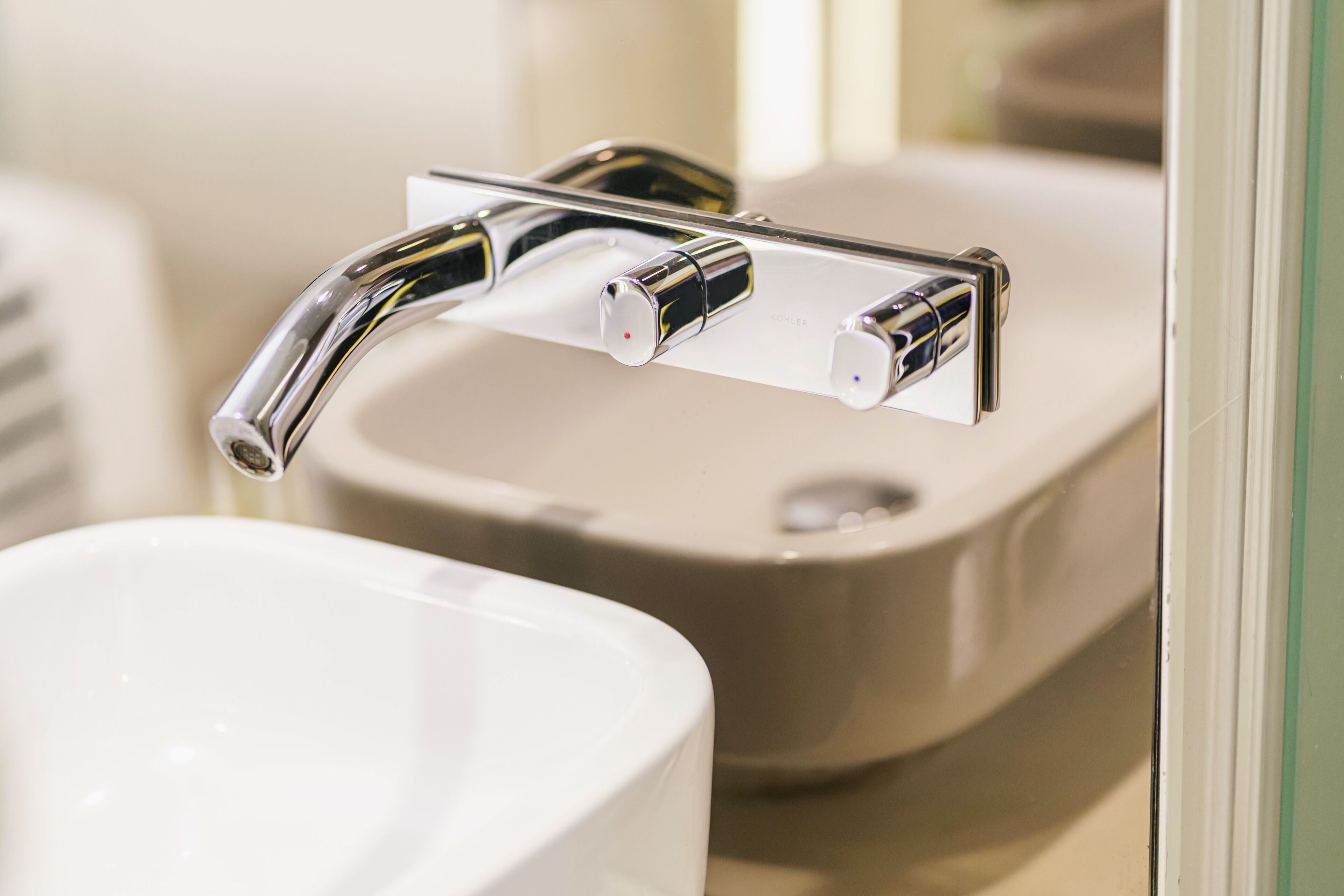 A modern bathroom with a chrome faucet and a white sink.