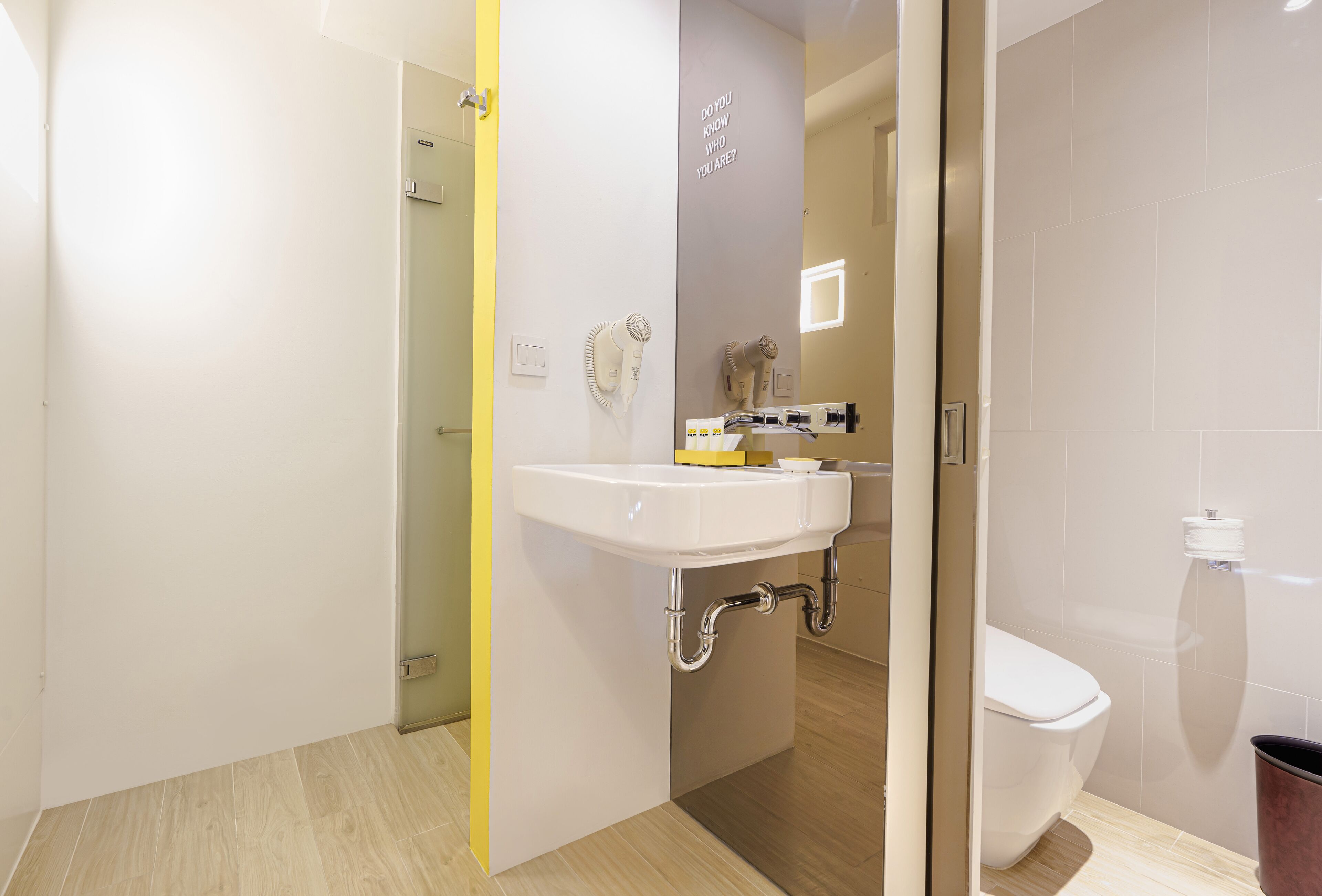 A modern bathroom with a white sink, a toilet, and a shower area.