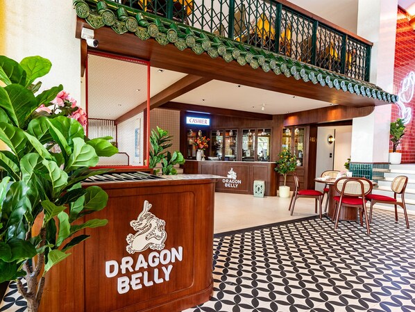 A reception area with a Dragon Belly sign, a cashiers counter, and a seating area with chairs and a table. - Mood Hotel Pattaya (Pattaya)