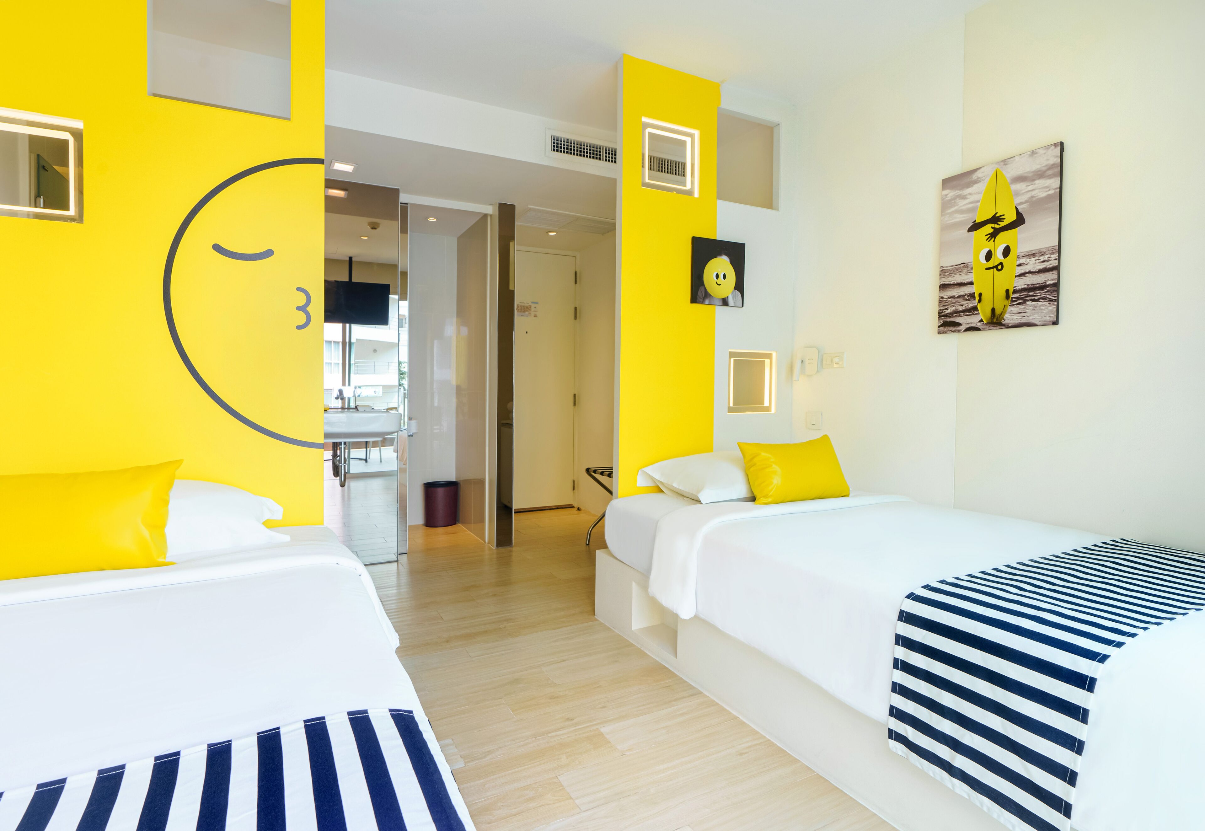 A hotel room with two beds, a large window, and a view of the beach.