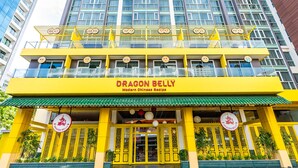 A building with a yellow facade and a sign reading "Dragon Belly Modern Chinese Recipe". - Mood Hotel Pattaya (Pattaya)