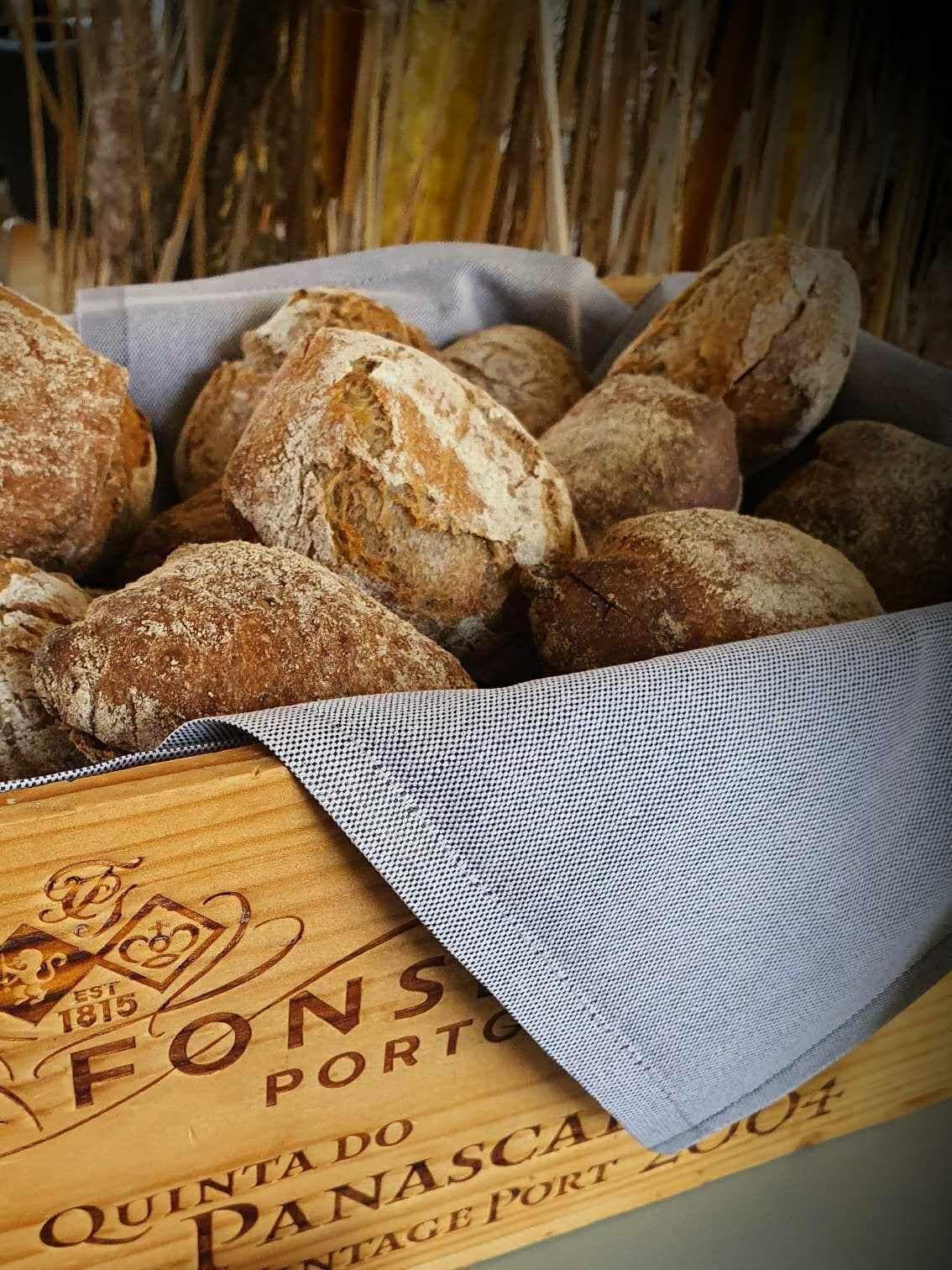 Una caja de madera con pan y un paño con texto.